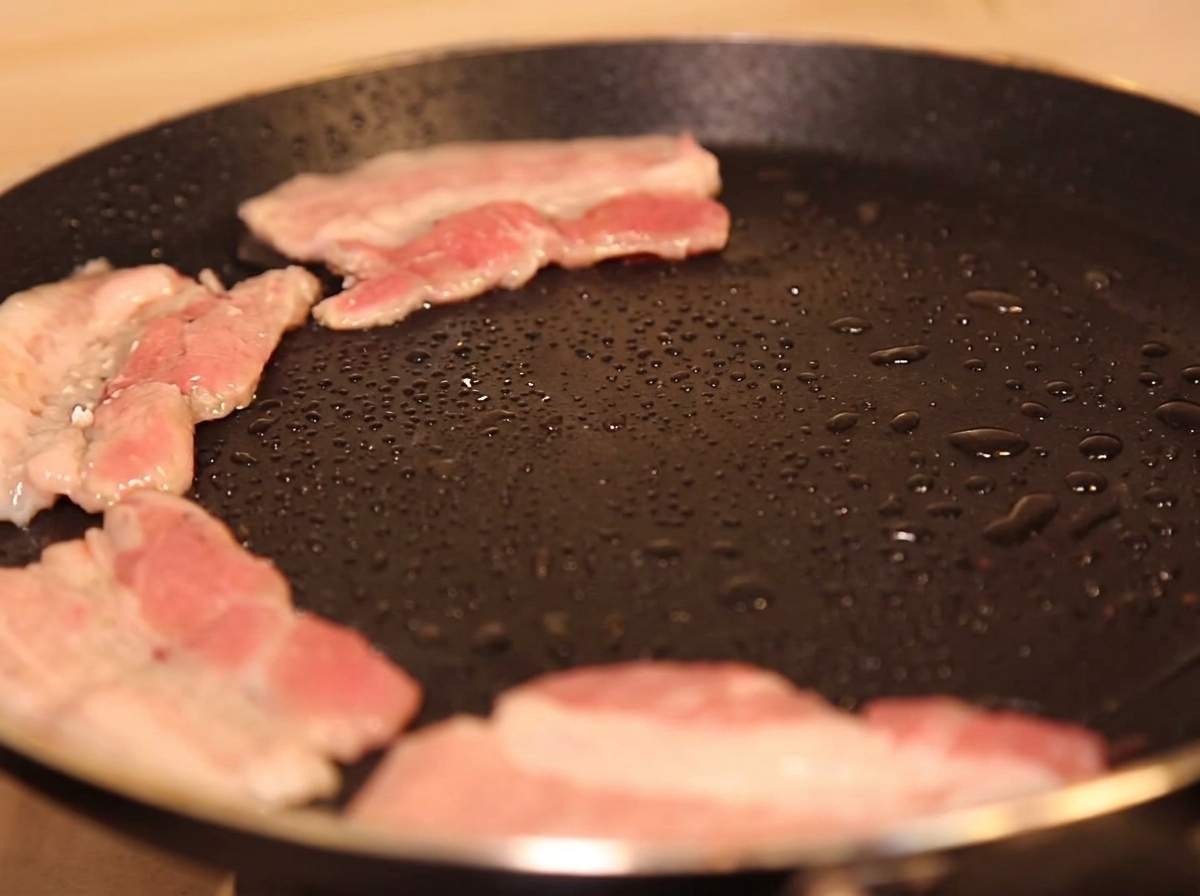 フライパンで豚バラ肉を香ばしく焼いている様子。