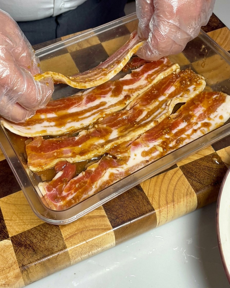 タレに浸かった豚バラ肉がタッパーに収められている様子。