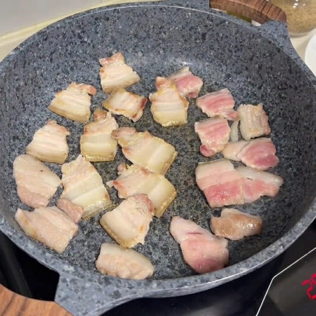 石鍋で豚バラ肉を焼き、こんがりと色づいている様子。