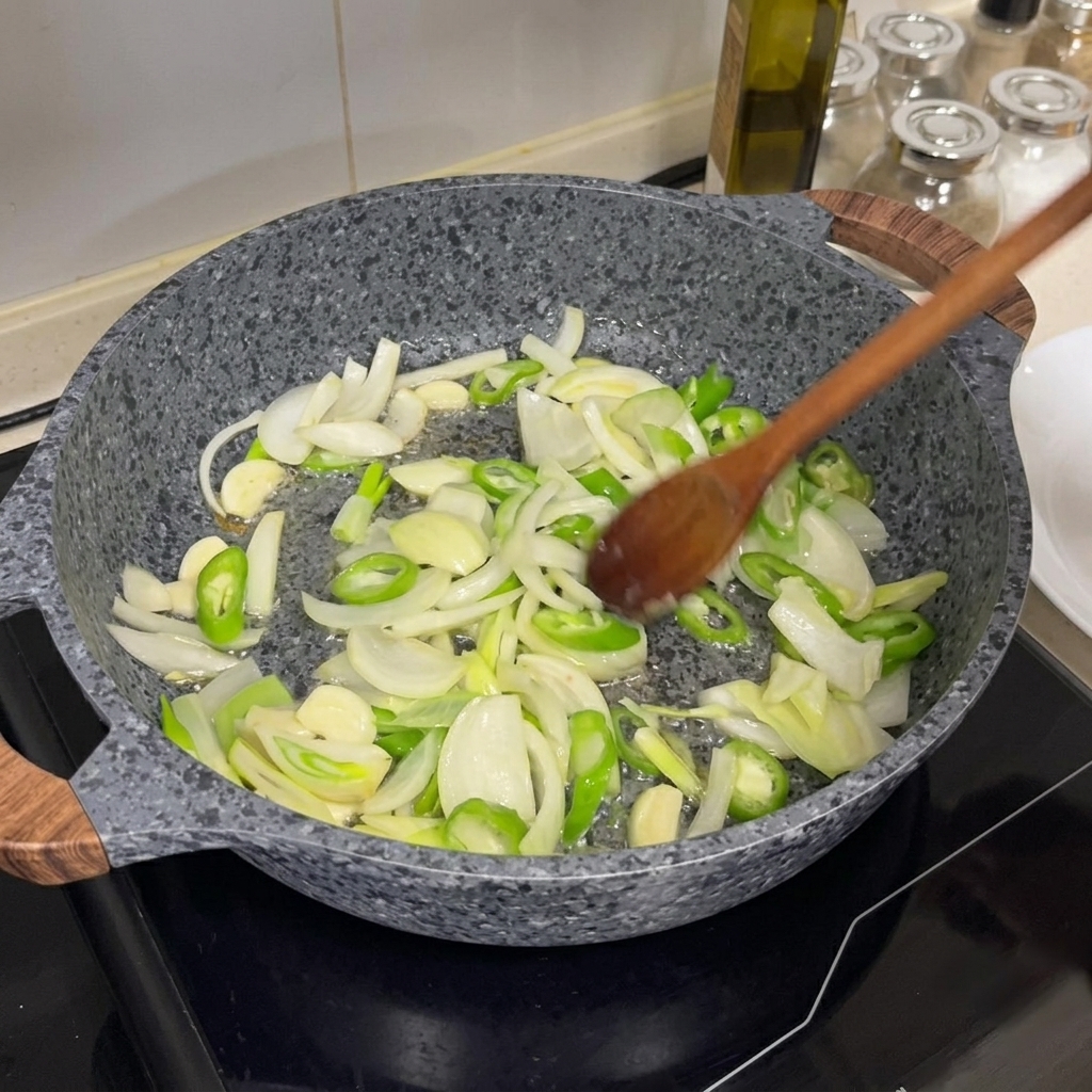 フライパンで野菜を木べらで炒めている様子。