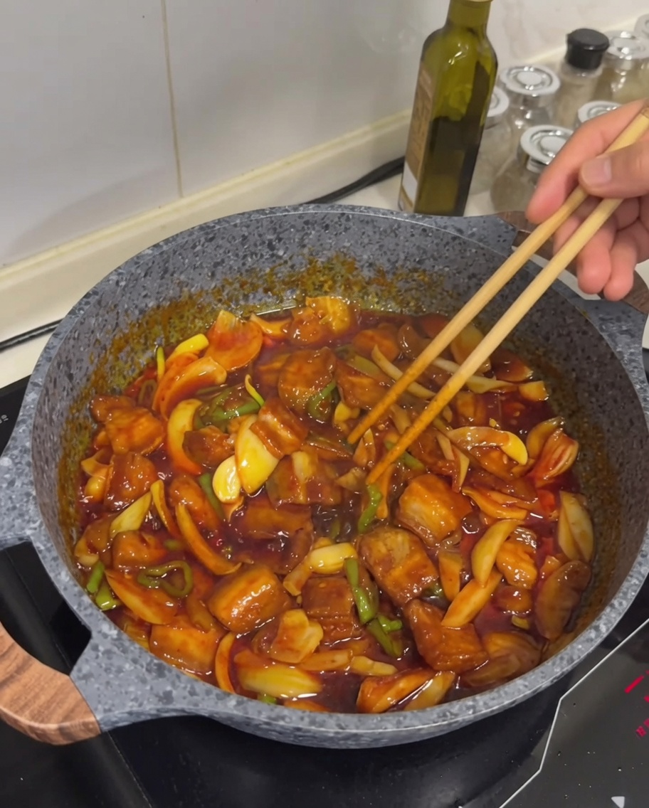 完成した料理に白ごまを振っている様子。