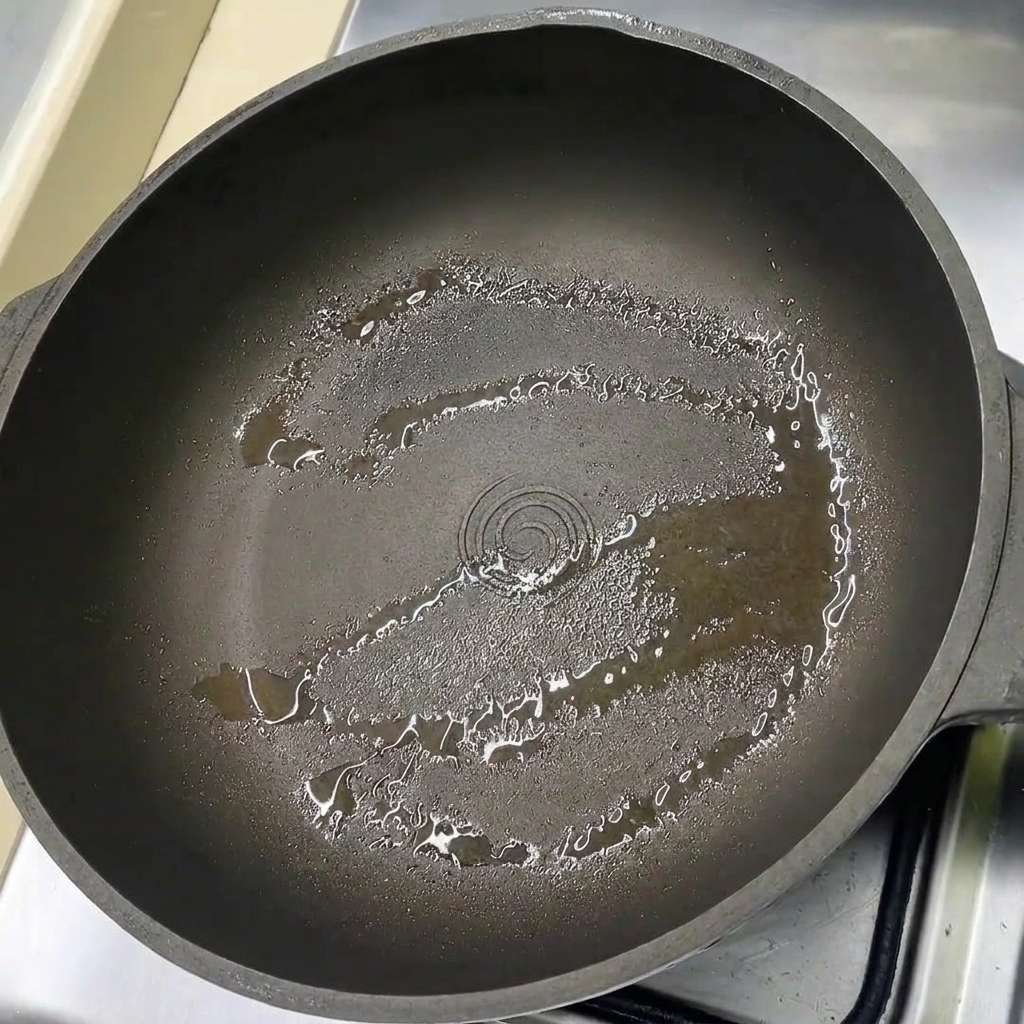 油を薄く引いたフライパンに豚バラ肉を並べている様子。