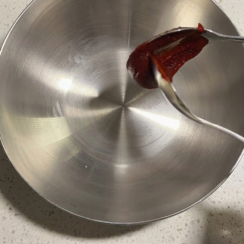 ボウルに入った調味料やソースを混ぜ合わせる様子。