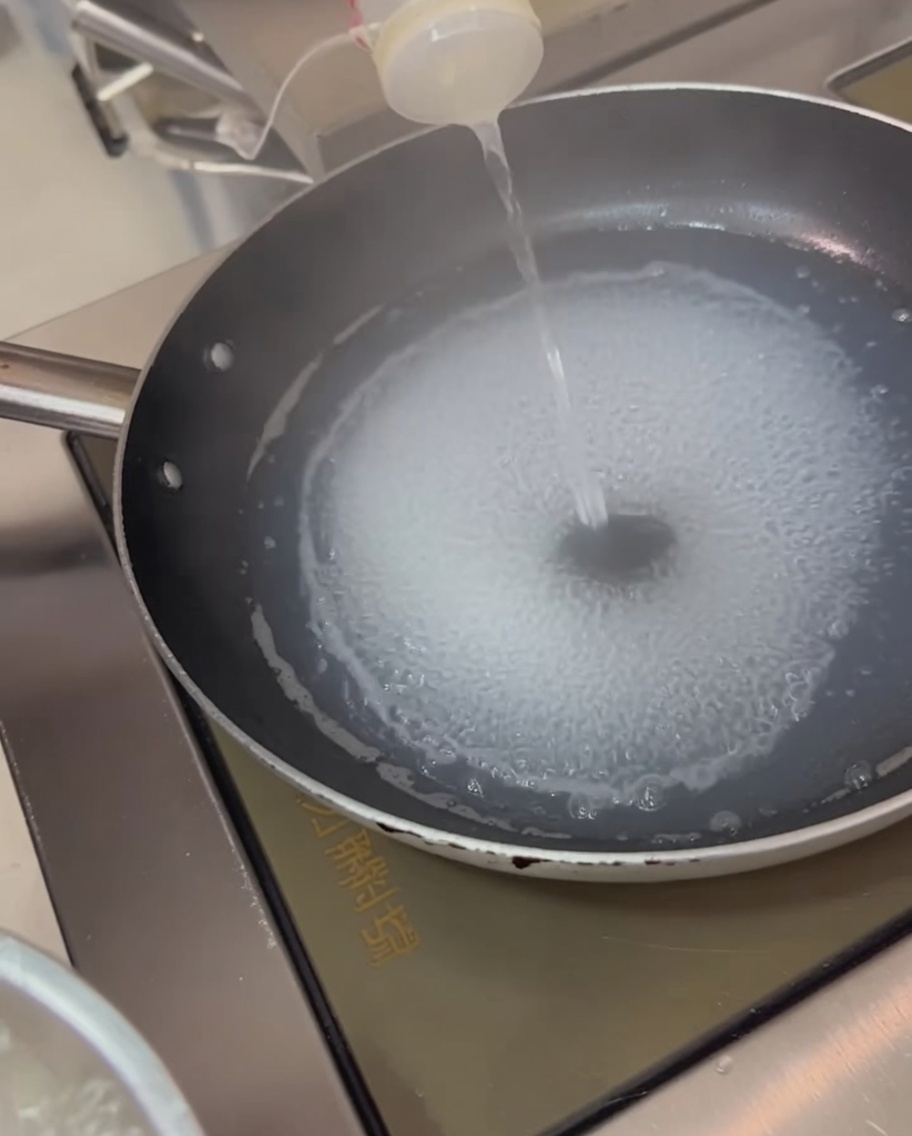沸騰した湯で湯通しされるイカの輪切り。