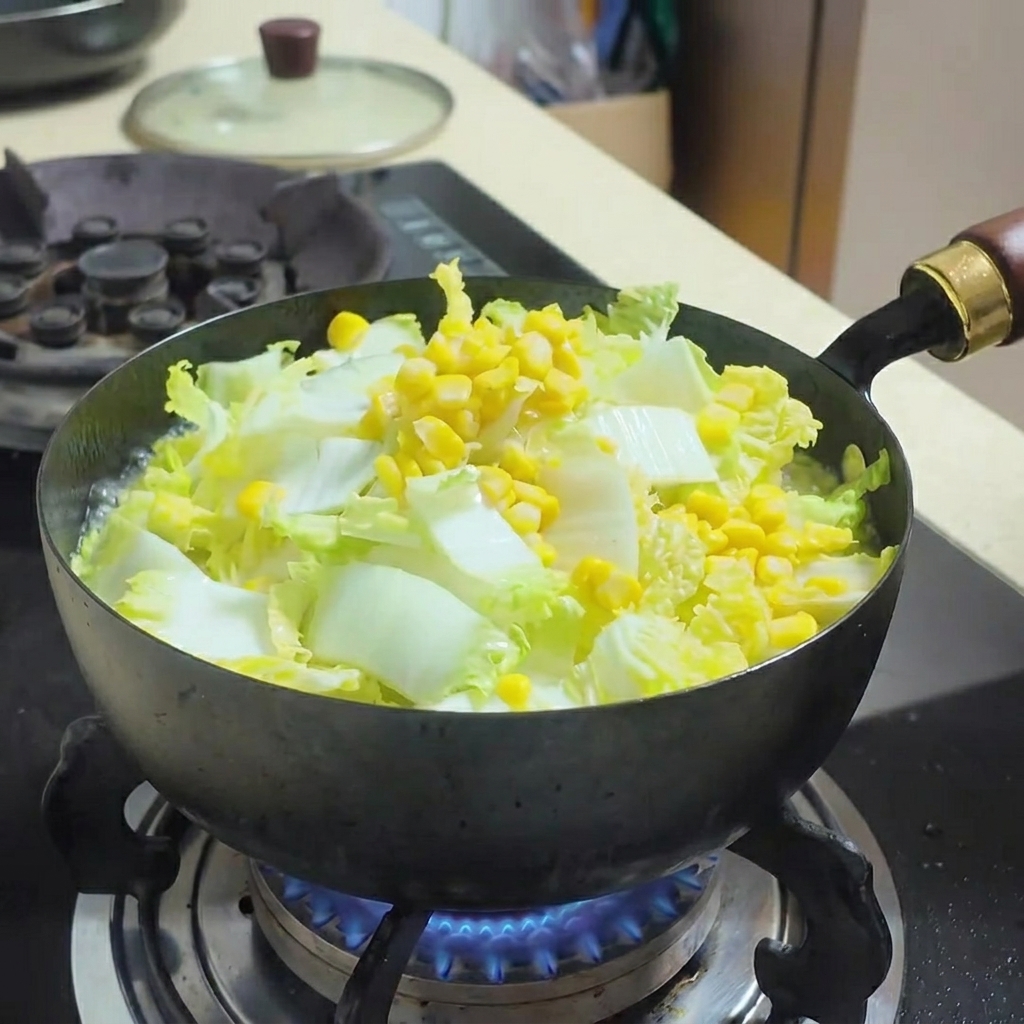 煮立っている野菜と豆腐の入ったスープに、水煮ツナを混ぜ入れている様子。