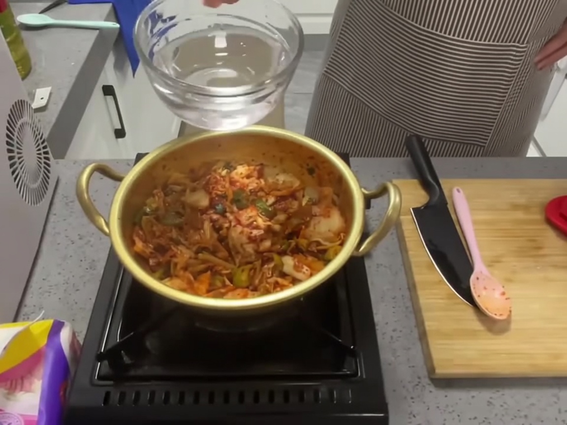 炒めた具材に水を注いでいる様子。
