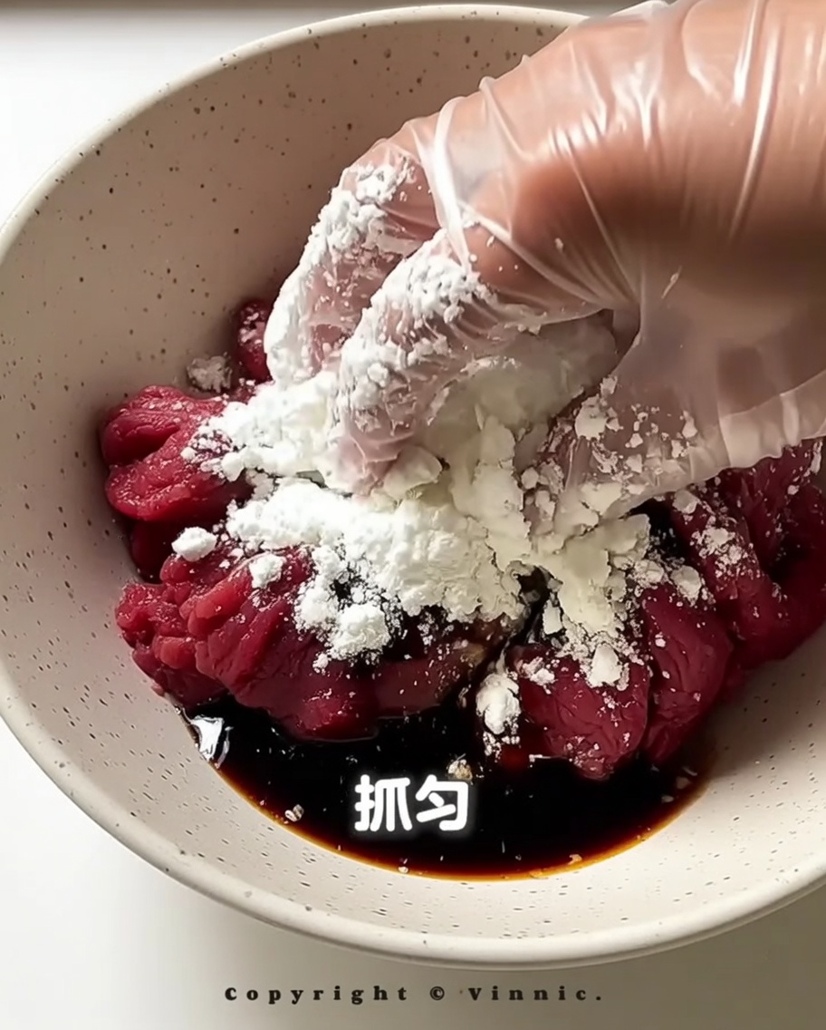調味料が均等に行き渡るように、ボウルの中で牛肉を手で揉み込んでいる様子。
