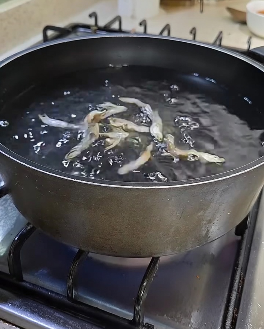 水とだし用煮干しが入ったコンロの上の黒い鍋。