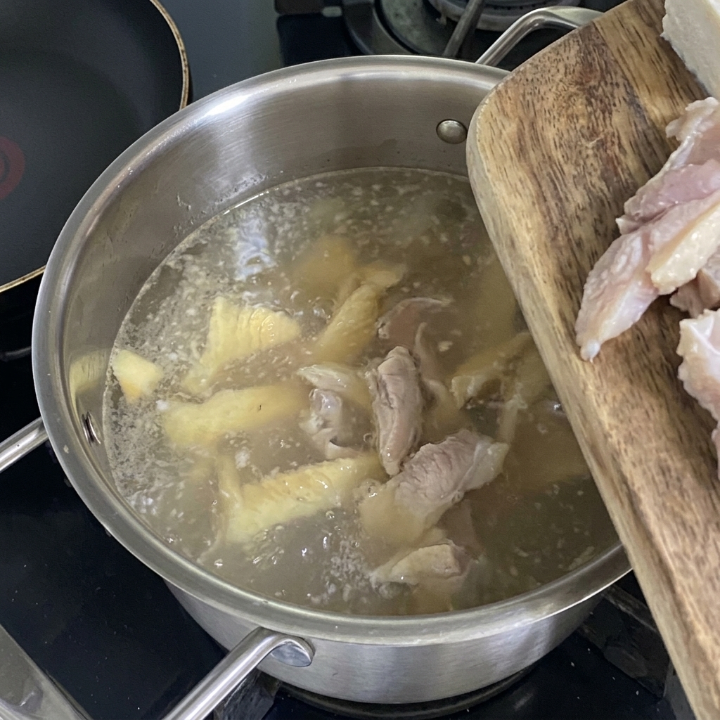 白濁したスープに豆腐と溶き卵を加える様子。