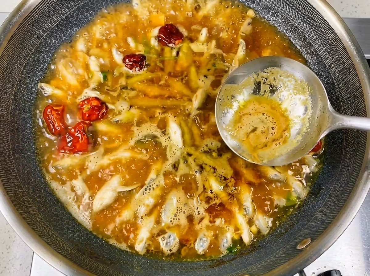 豊かで風味豊かなスープの中で煮立っている小魚のクローズアップ。