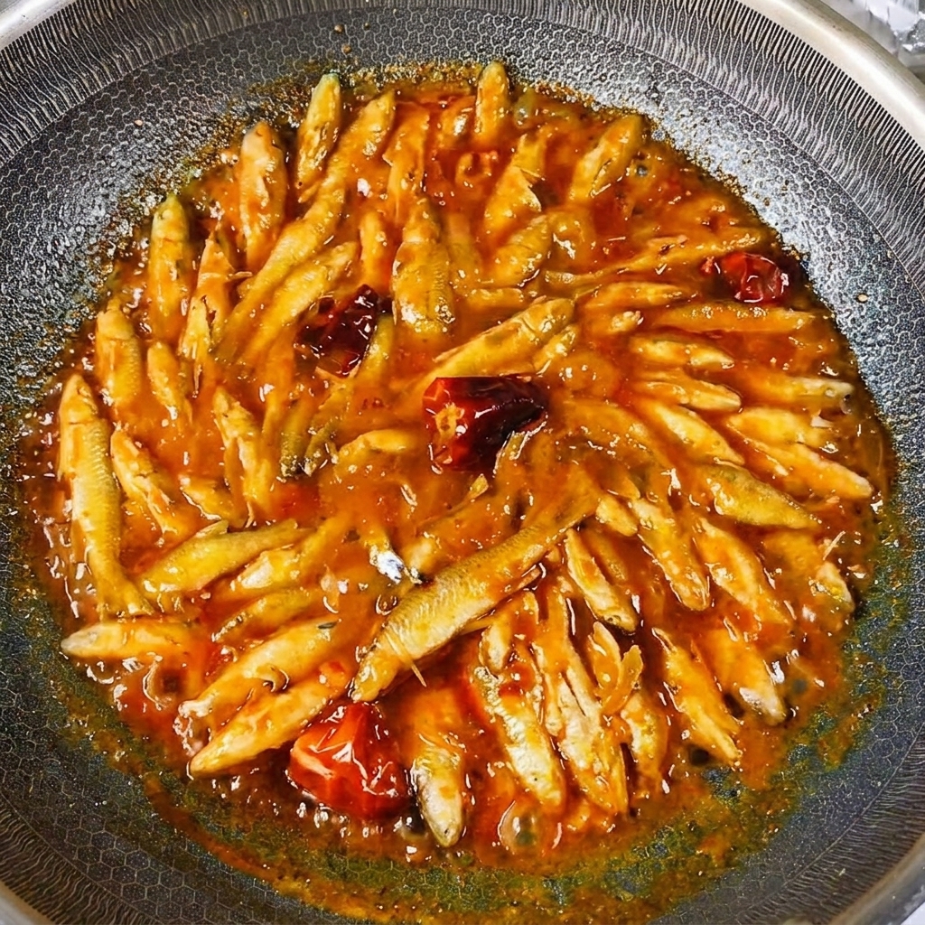 中華鍋の中でとろみのある濃厚なソースに絡んでツヤツヤと輝く小魚。