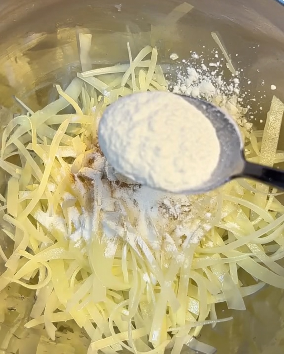 細切りにしたじゃがいもに小麦粉とコーンスターチをまぶしている様子。