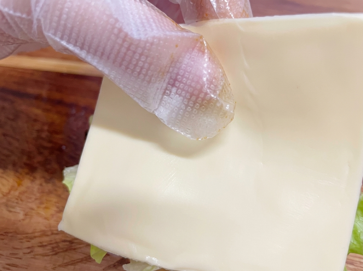鶏肉の上にチーズをのせている様子