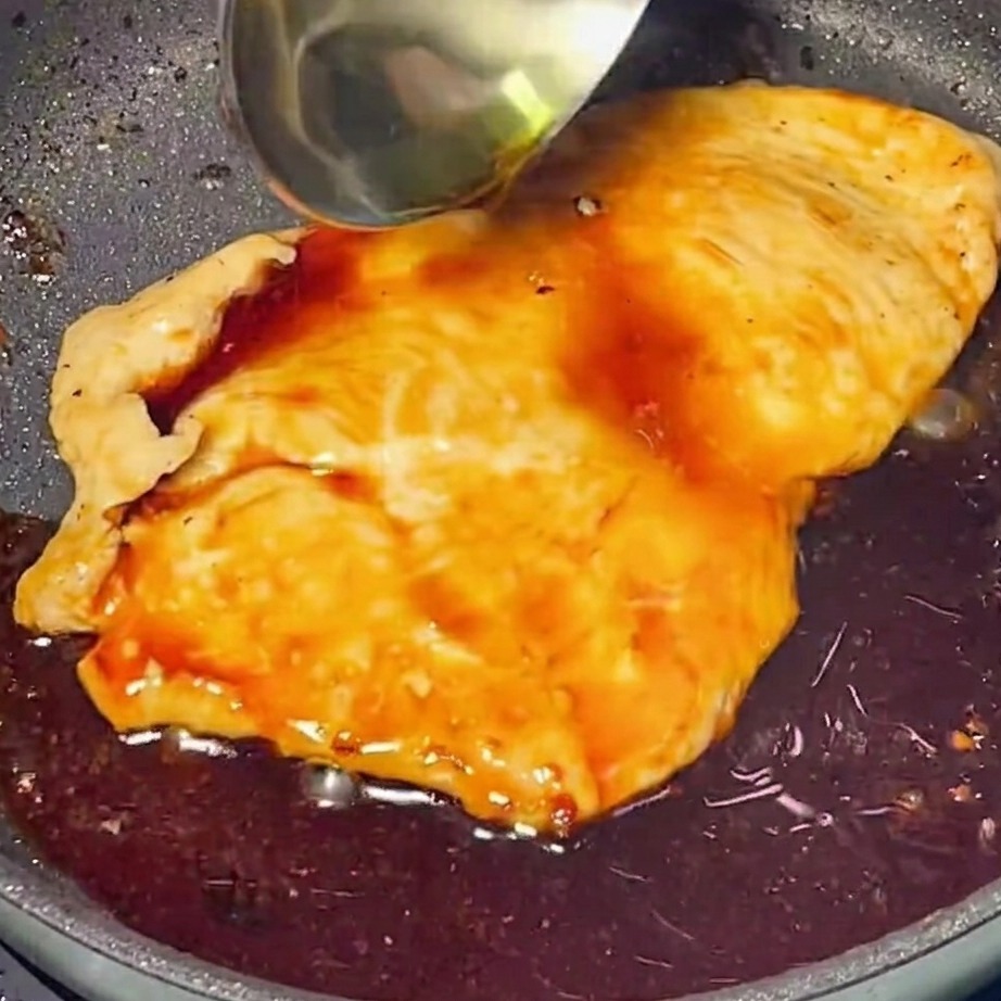 焼いた鶏肉にテリヤキソースを加えて絡めている様子。