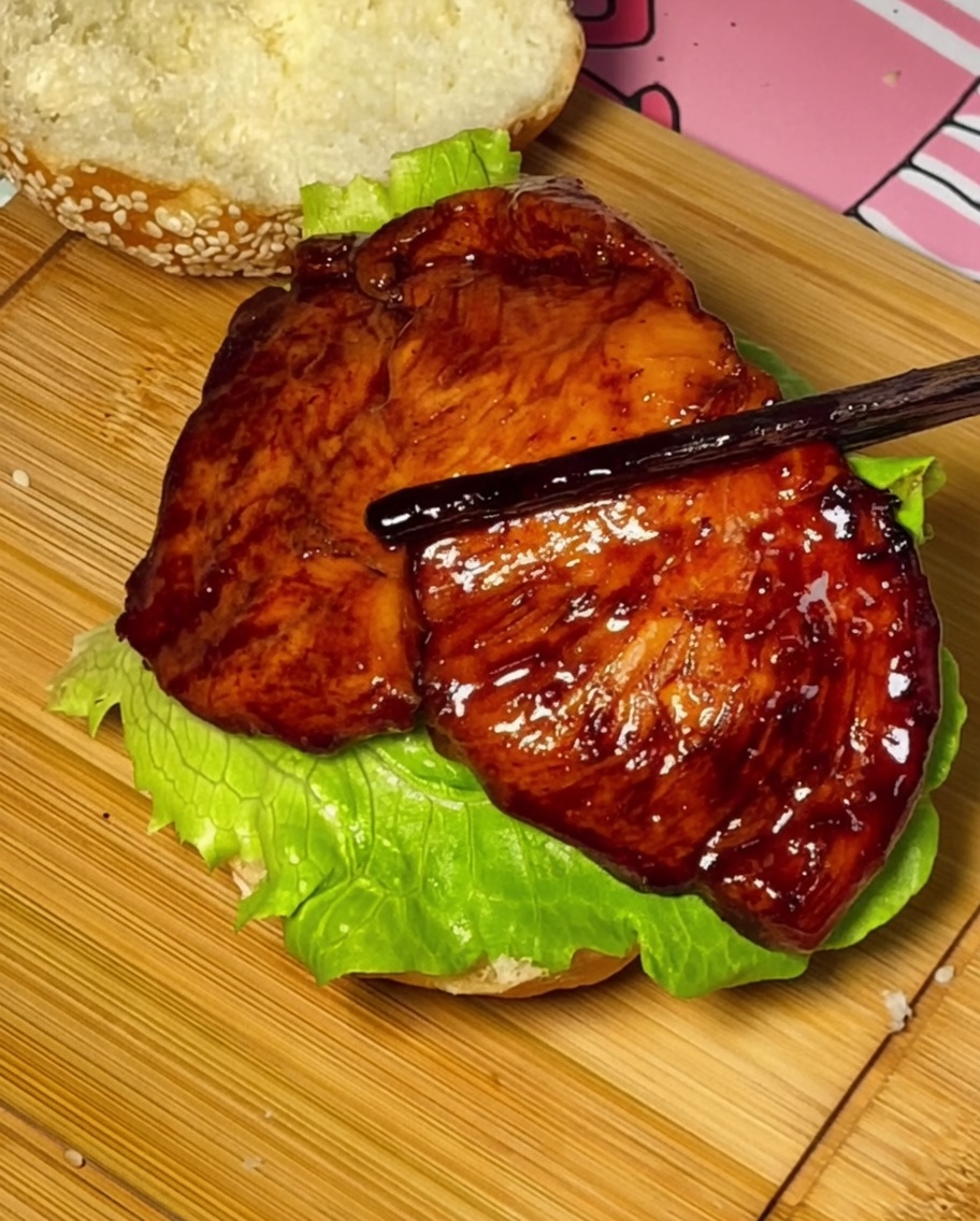 バンズの上にテリヤキチキン、トマト、チーズを乗せて完成したバーガー。