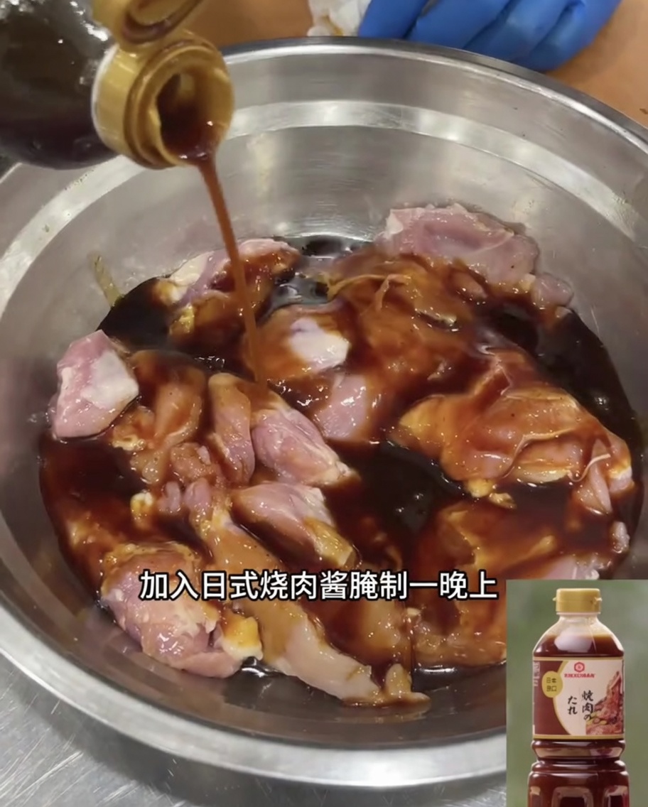 ステンレスボウルに入った鶏もも肉が、たっぷりのテリヤキソースに浸かっている様子。