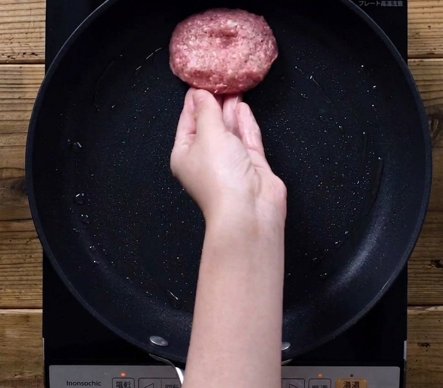 フライパンでハンバーグを焼いている様子