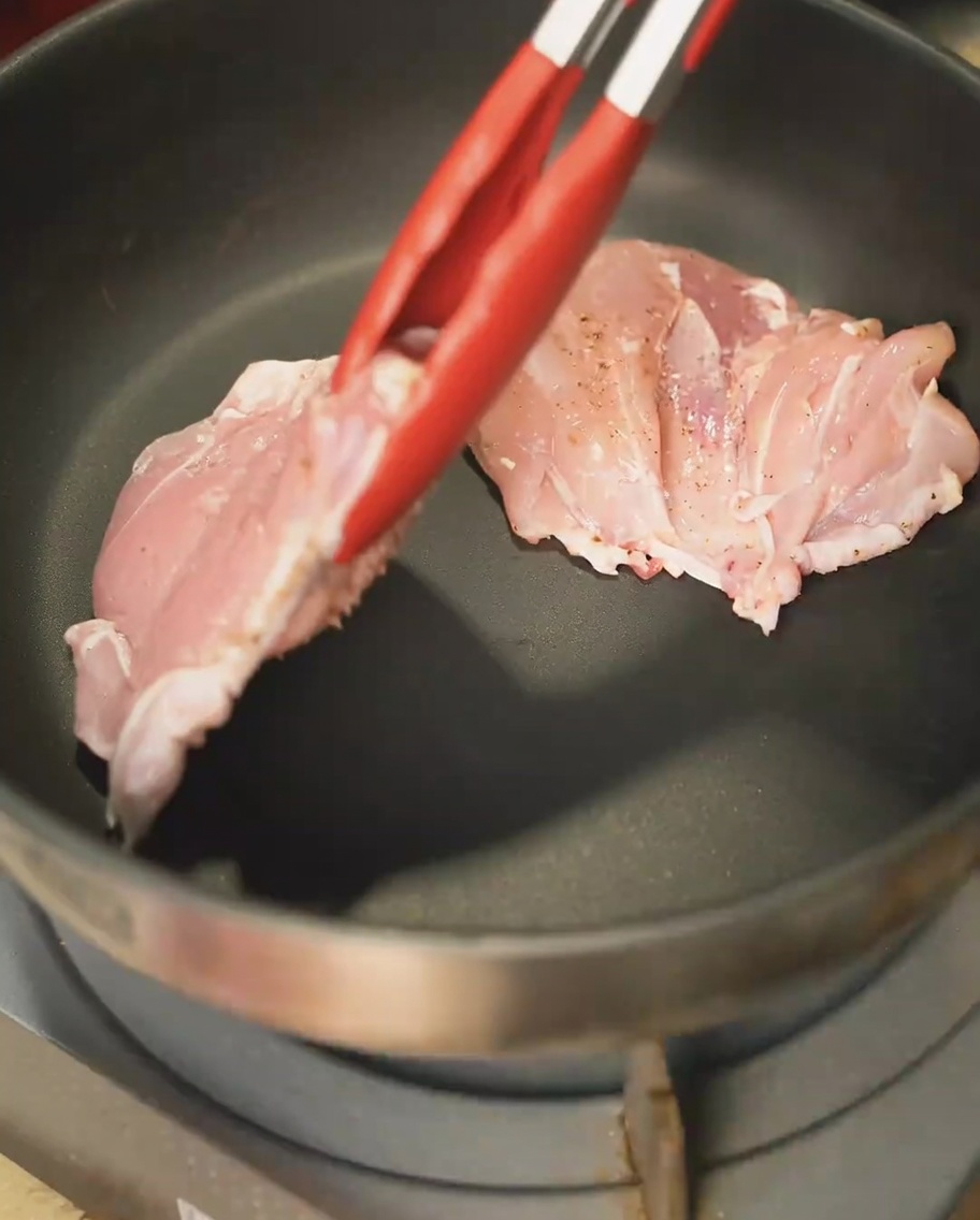 フライパンで皮目を香ばしく焼いている鶏もも肉。