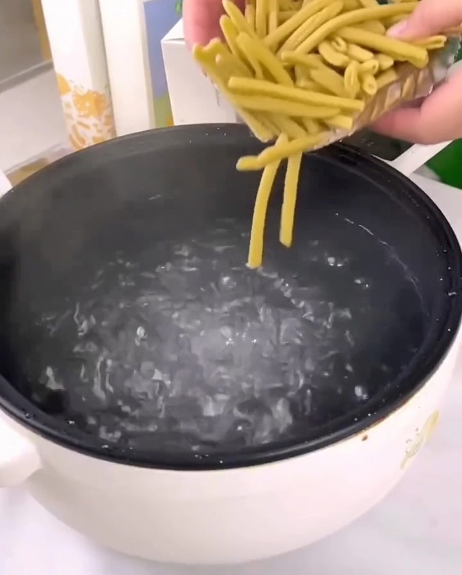 鍋の沸騰したお湯に乾燥きびペンネを入れている様子。