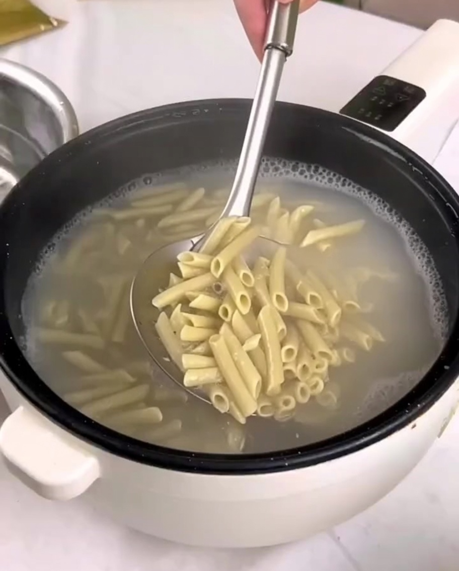 茹で上がったペンネを冷水の入ったボウルに移している様子。
