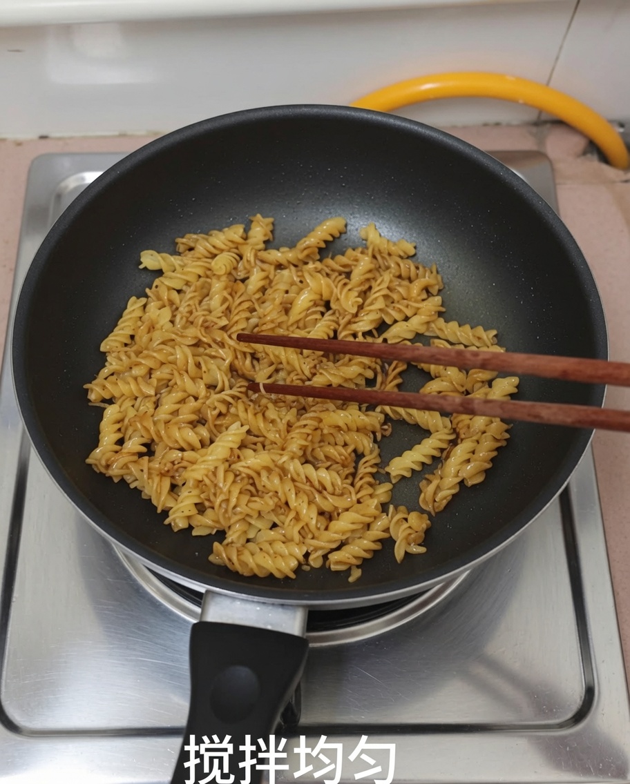 菜箸を使って、フライパンの中でパスタと黒胡椒ソースを混ぜ合わせている様子。