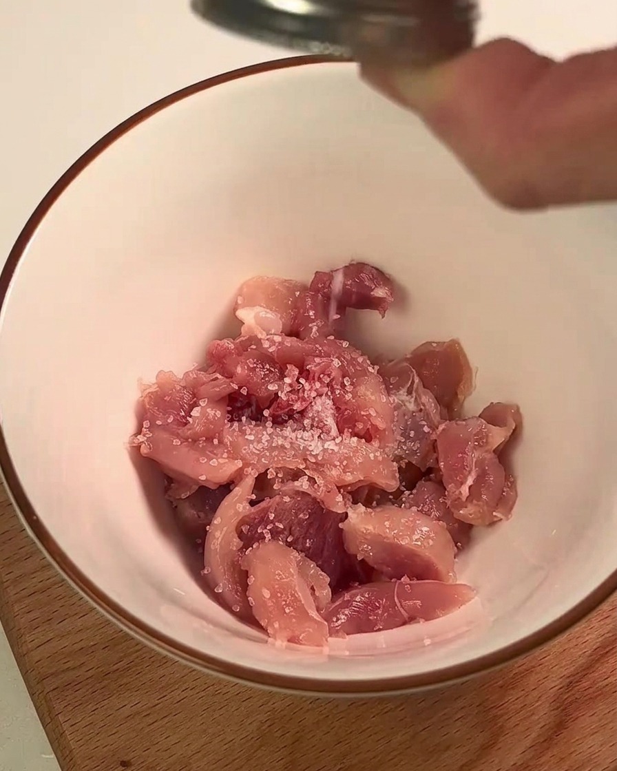 ボウルで鶏肉に塩とレモン汁を揉み込んでいる様子。