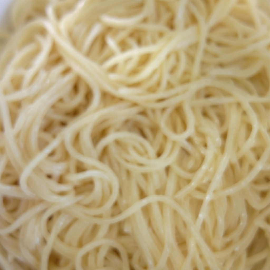 茹で上がったパスタに油を絡めているボウル。