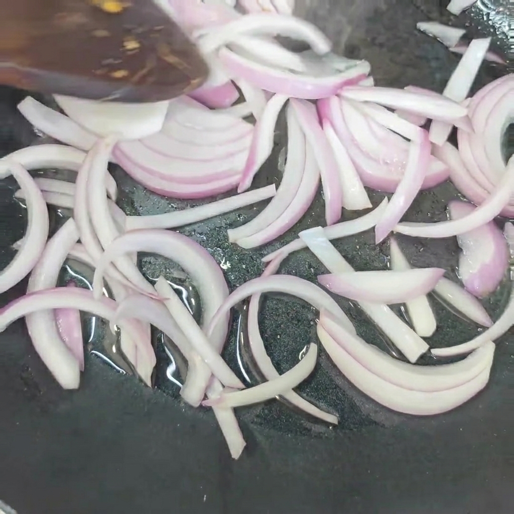 玉ねぎをフライパンで炒めている様子。