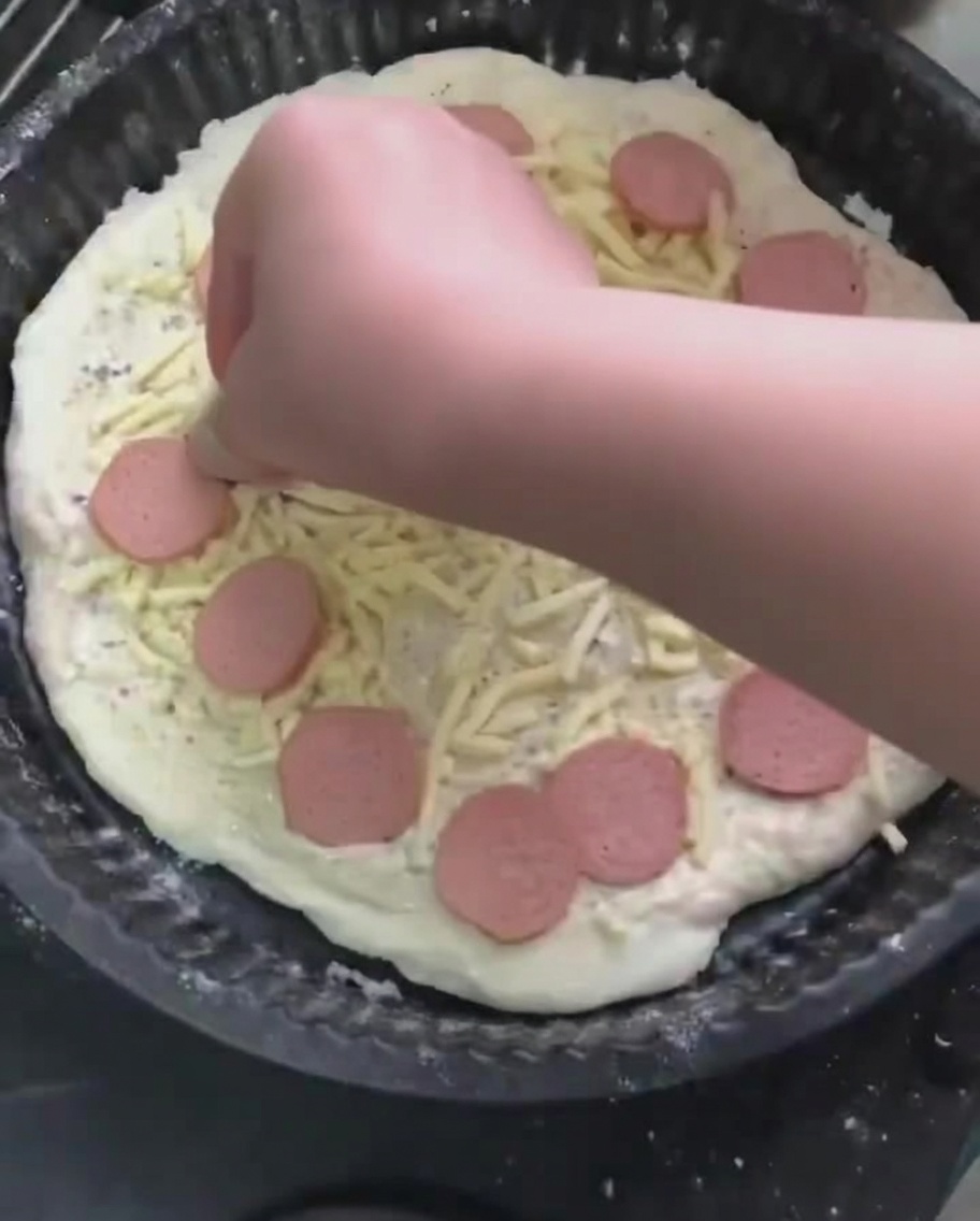 チーズの上にソーセージのスライスを並べている様子。