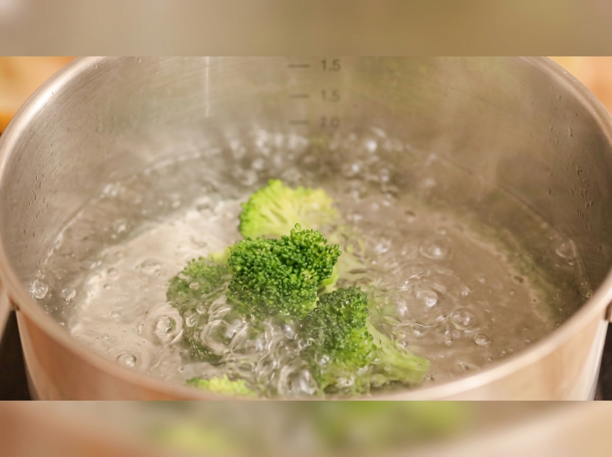 鍋でブロッコリーと花型の人参を茹でている様子。