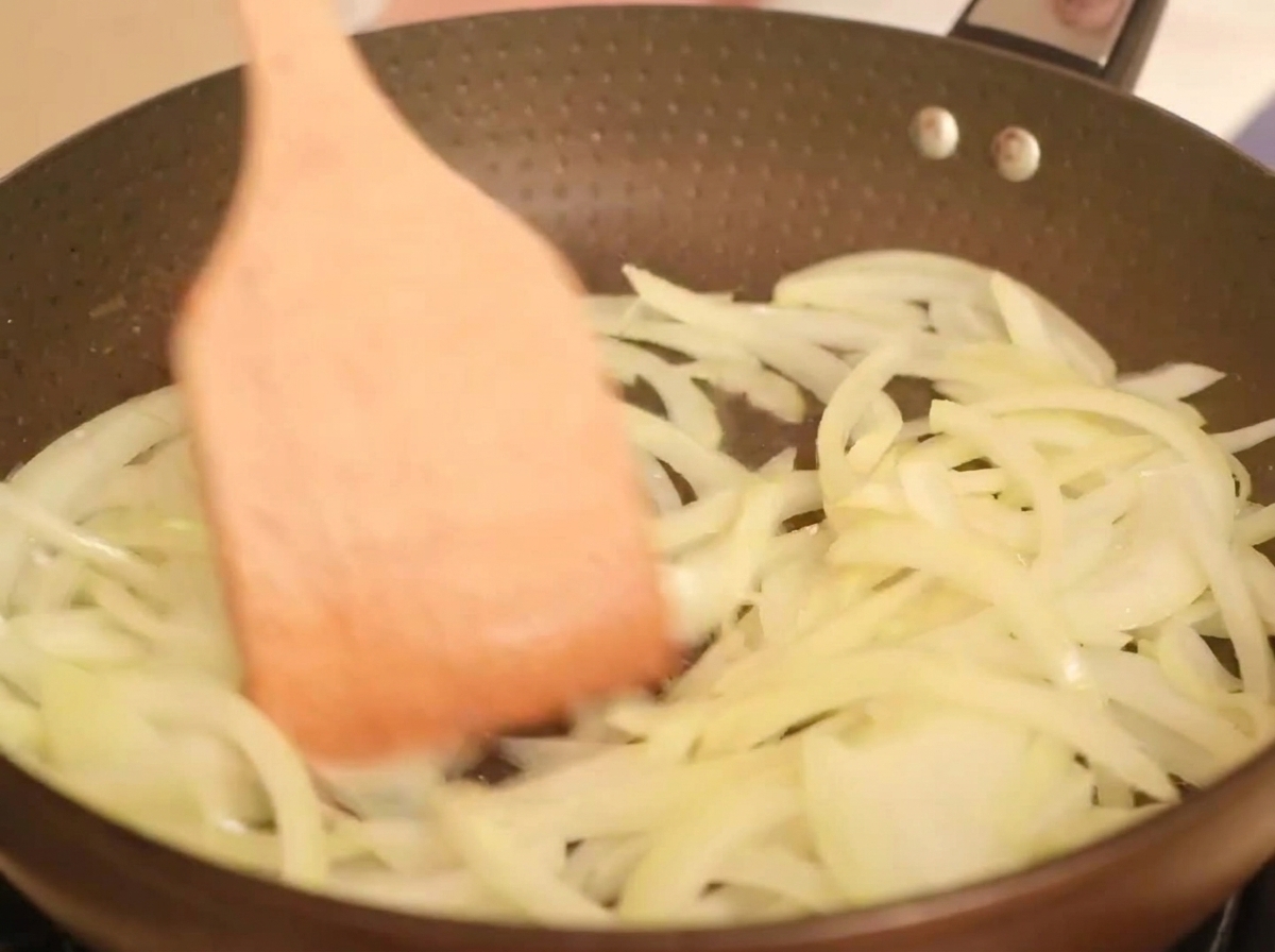 熱したフライパンで玉ねぎを炒めている様子。