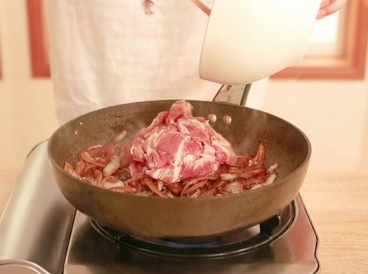 フライパンで牛肉をタレと絡めながら炒めている様子。