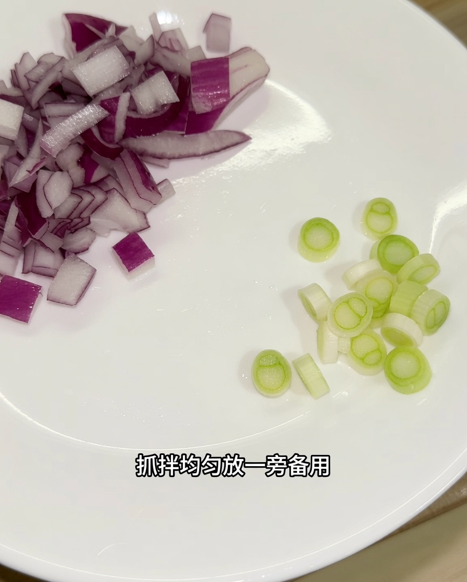 まな板の上で細かく刻んだ赤玉ねぎと、小口切りにした青ねぎの白い部分。