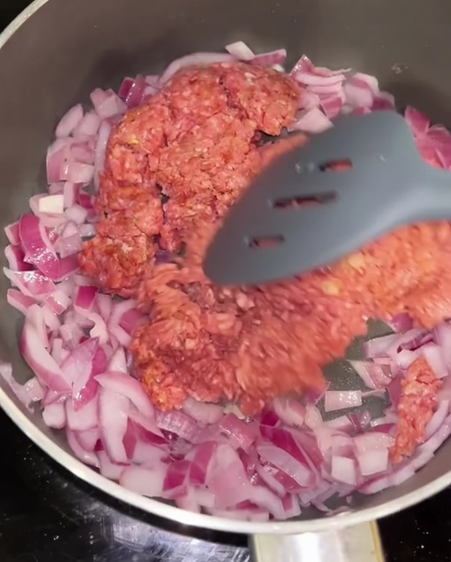 炒めた赤玉ねぎと一緒に、ひき肉をフライパンで炒めている様子。