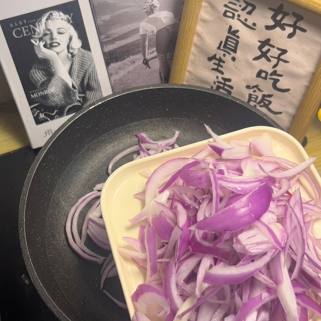 フライパンに均一に広げられた紫玉ねぎのスライス