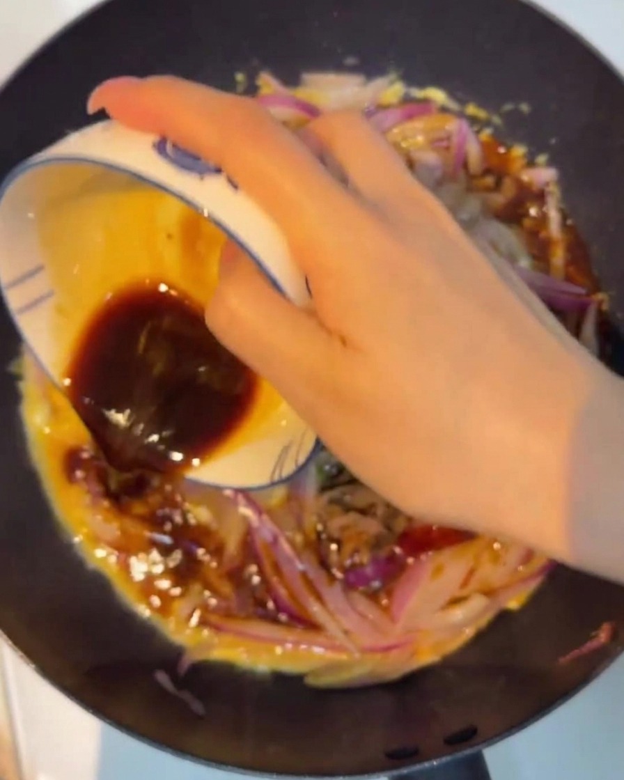 タレを加えて、牛肉と卵が艶やかにコーティングされている様子。