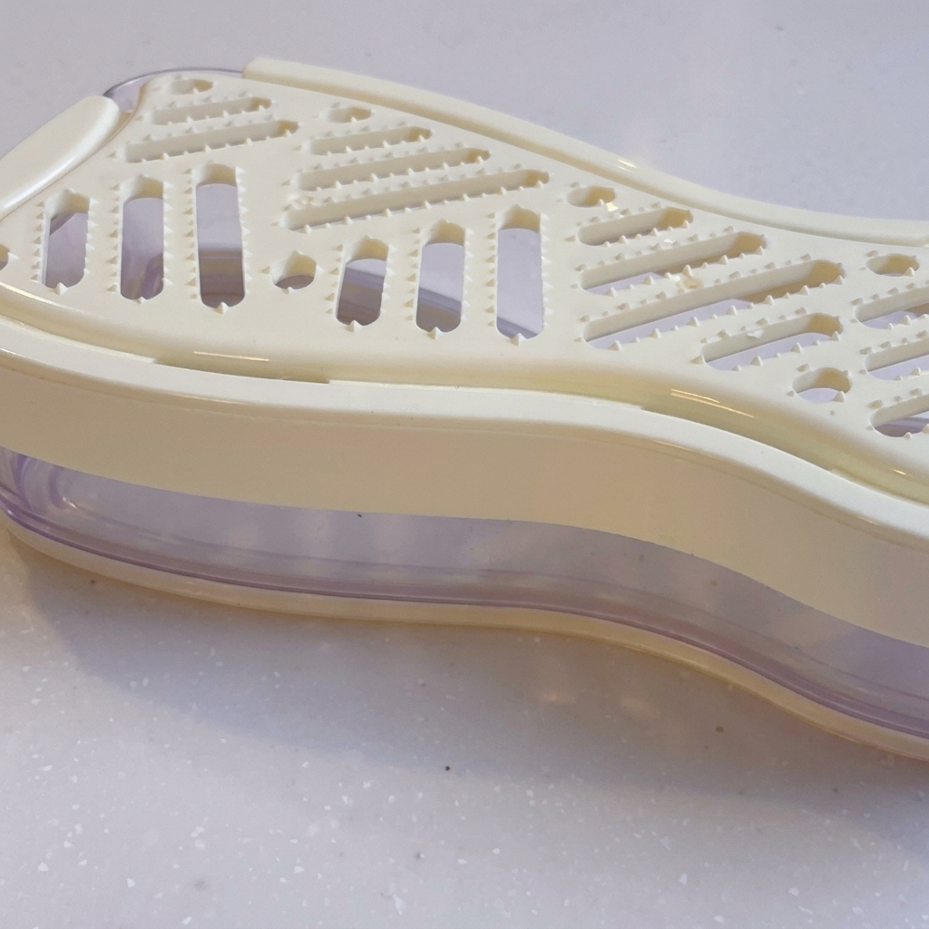 手動のおろし器で大根をすりおろしている様子。