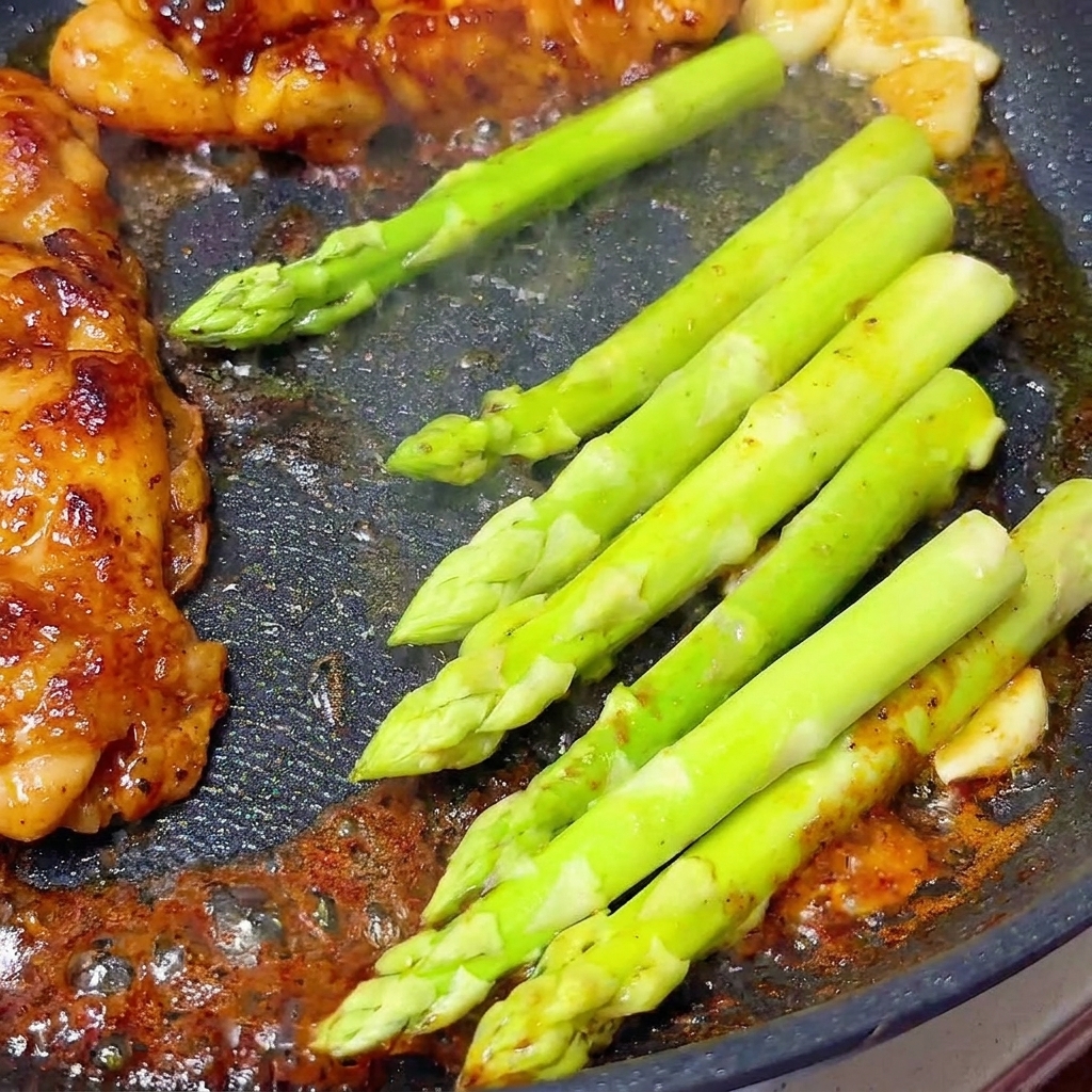 鶏肉の隣にアスパラガスを並べている様子。
