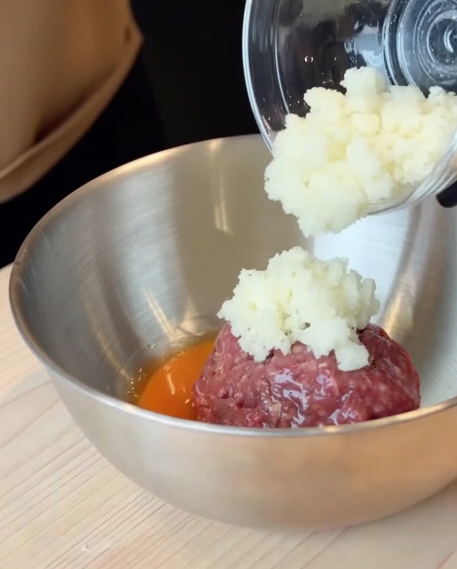 大きなステンレスボウルに入ったひき肉と卵、刻んだ玉ねぎ。