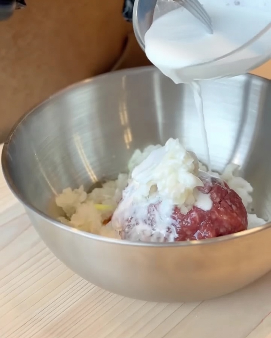 肉ダネのボウルにバッター液を流し込んでいる様子。
