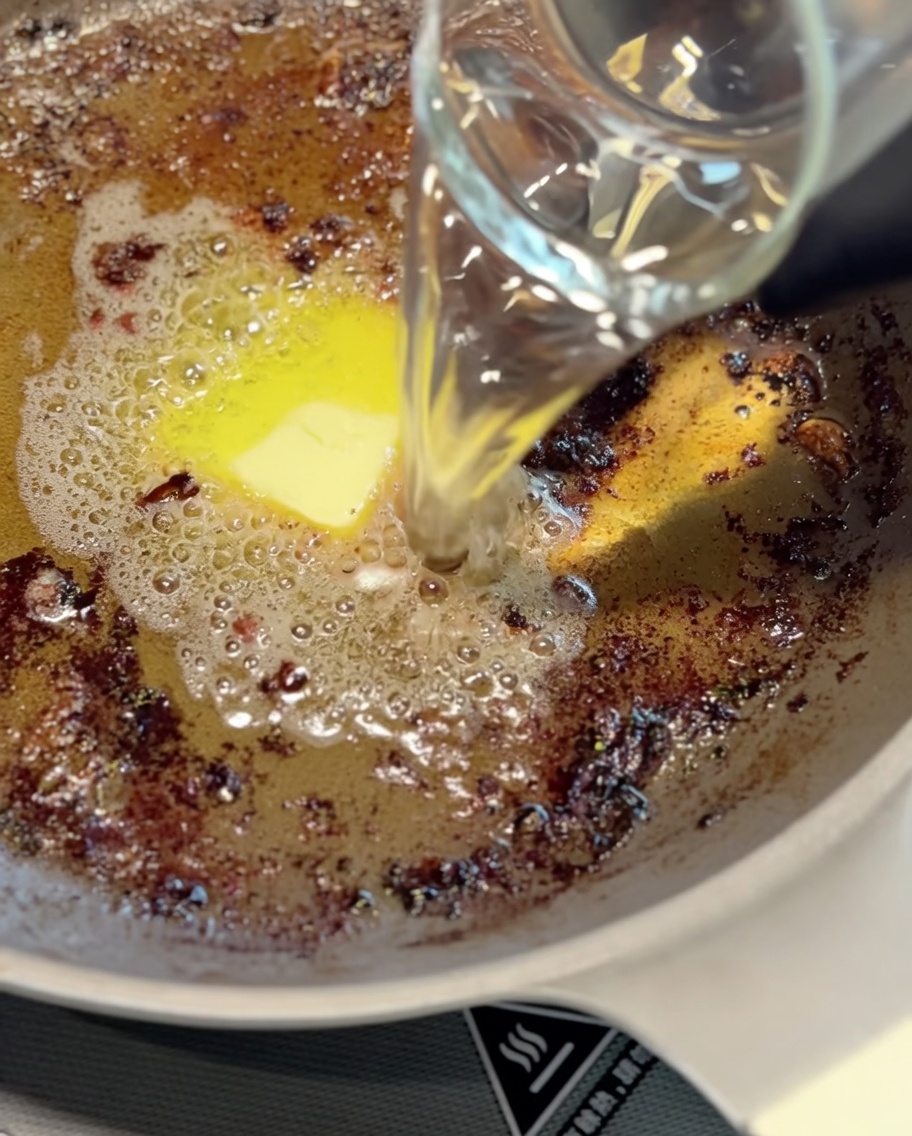 フライパンに残った肉汁でソースを作っている様子。