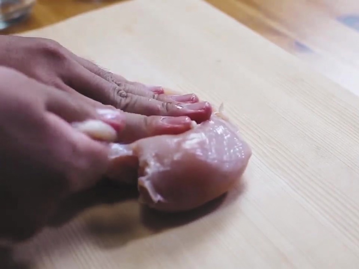 まな板の上で塩を振られた生の鶏むね肉。