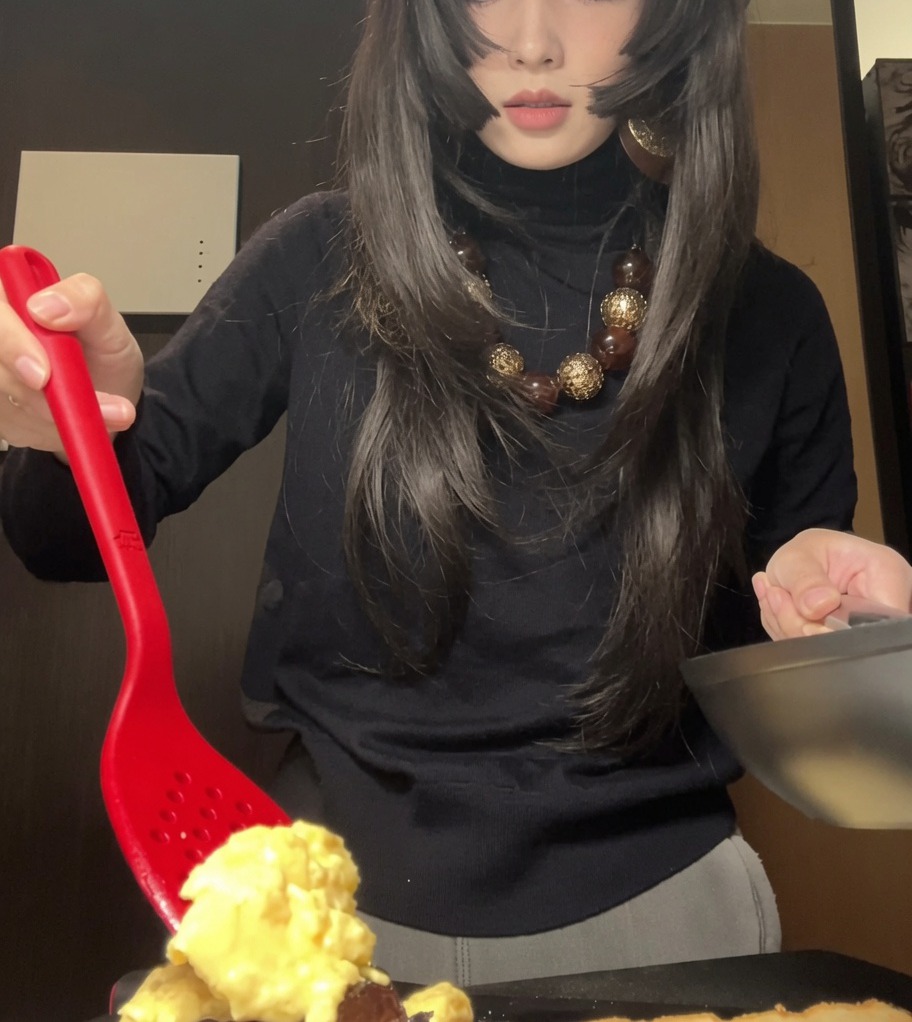 トーストの上のチキンの上に、ふんわりとしたスクランブルエッグを優しくのせている様子。