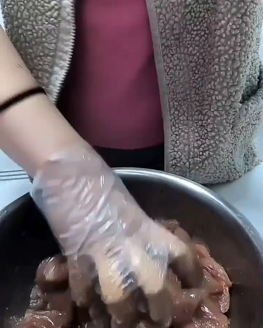 下味をつけた豚肉の上から調理用油を回しかけている様子。