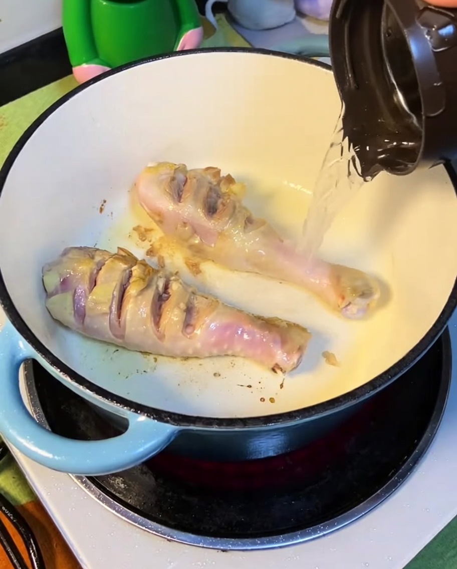 焼き色がついた鶏肉に熱湯を注いでいる様子。