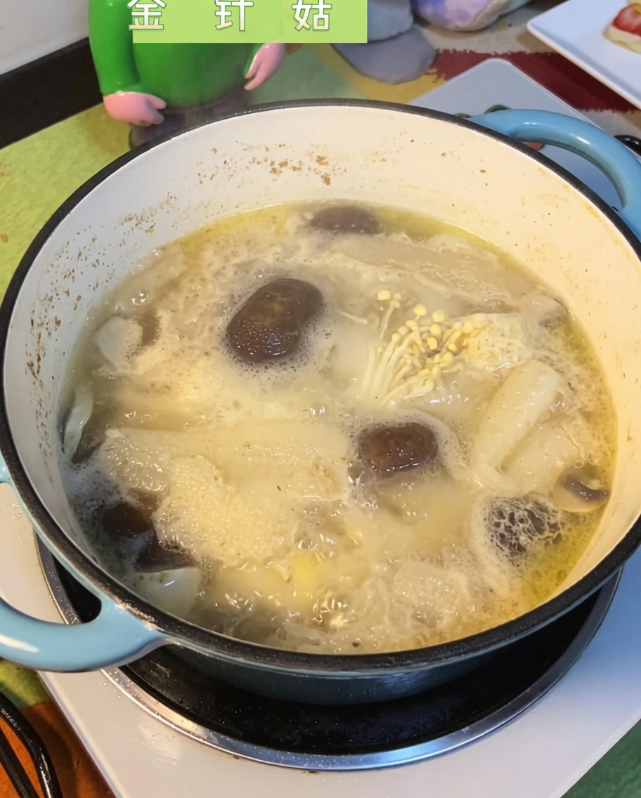 沸騰したスープにえのき茸を加えている様子。