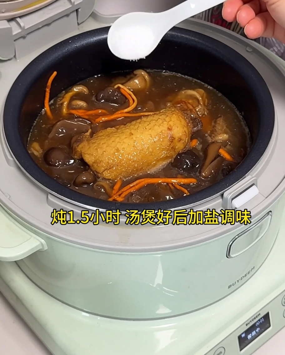 炊飯器で完成したスープに塩を加えている様子。
