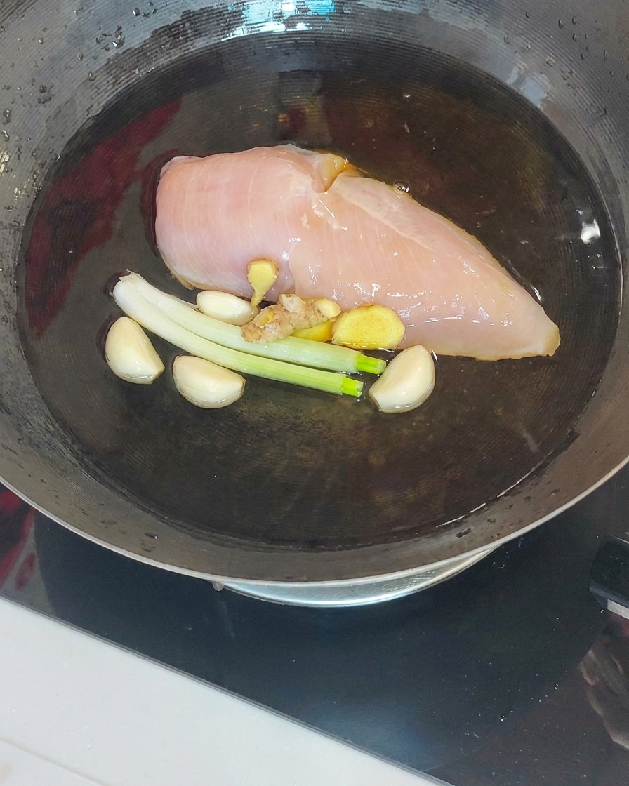 茹で上がった鶏肉を鍋から取り出す様子
