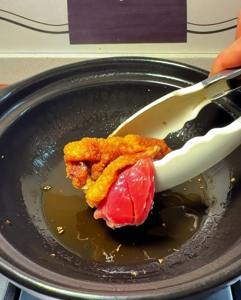 土鍋で表面に焼き色をつけている鶏肉。