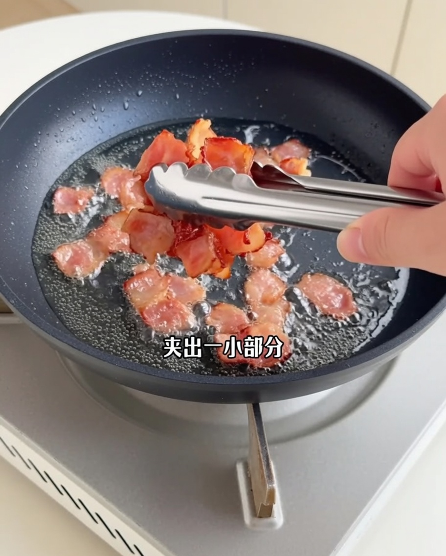 カリッと焼けたベーコンを金属製のトングでフライパンから取り出している様子。